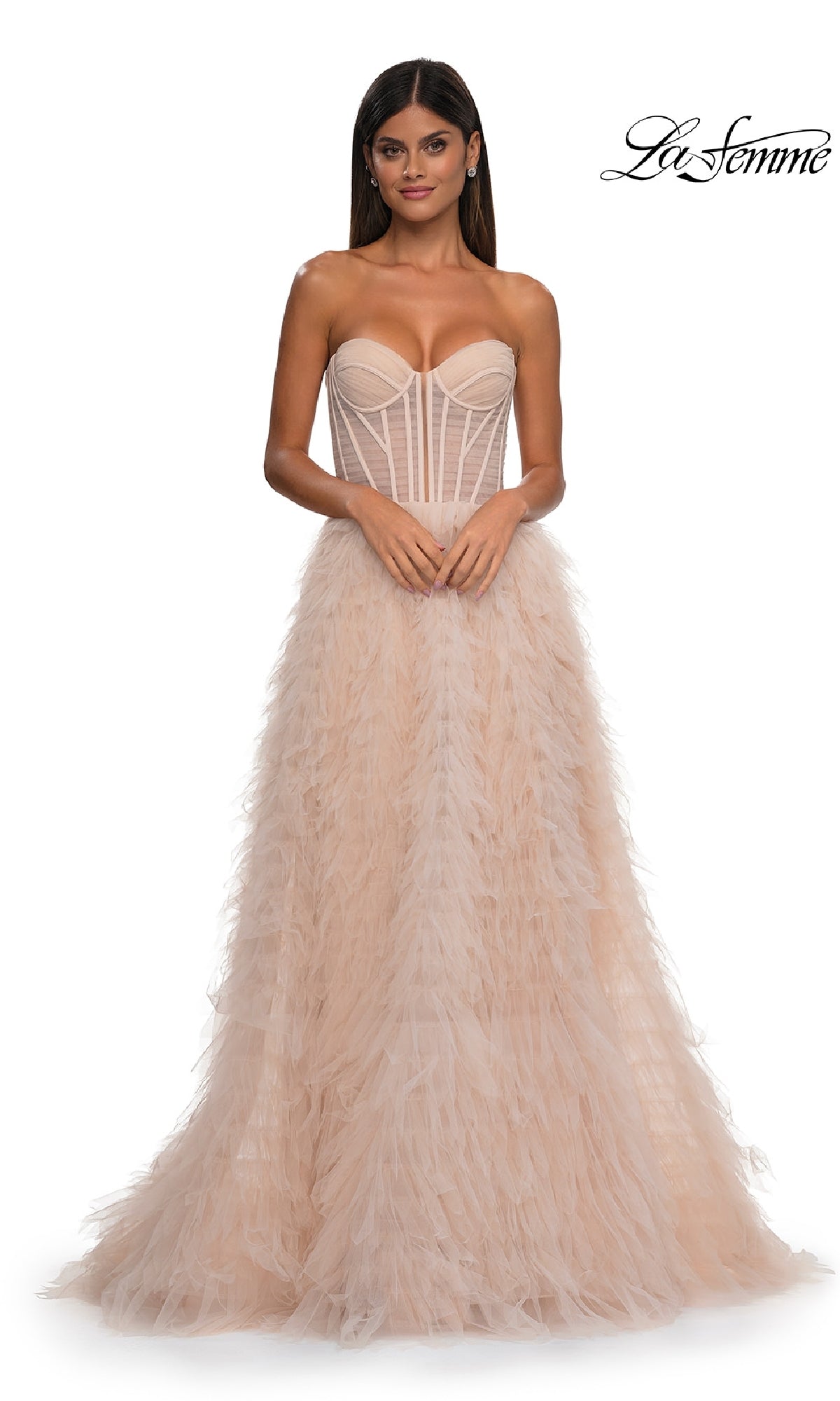A woman in the Strapless Ruffled Prom Ball Gown: La Femme 32528, with a corset-style bodice and feathered tulle skirt, stands before a white background. The La Femme logo appears in the top right corner.